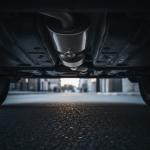 Primer plano de los bajos de un coche con el tubo de escape cortado por robo de catalizador